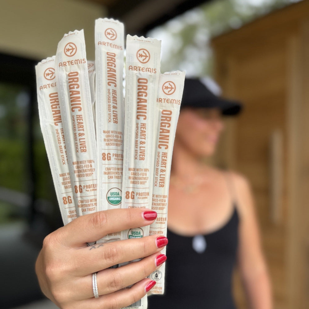 Hand holding a fan of Organic Heart & Liver Infused Beef Sticks