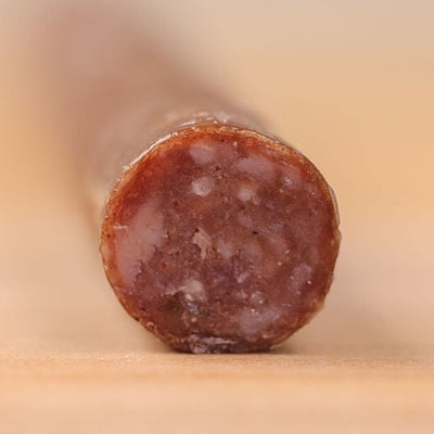 Close-up of a sliced Artemis beef stick, its marbling showing in the cut end.